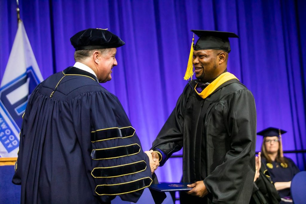 Graduate student from Ghana shaking hands with the President of Northwood University